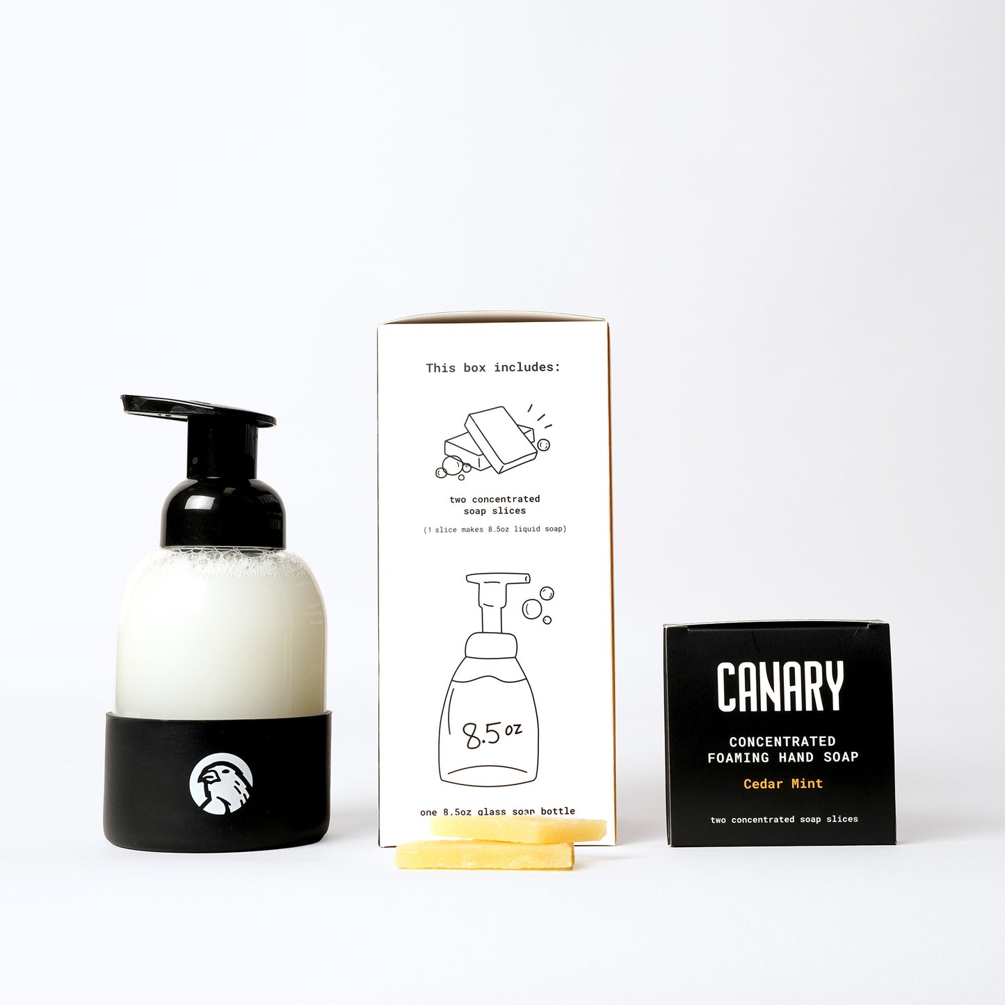 Image of Cedar Mint Foaming Hand Soap Starter Kit. Sustainable refillable glass bottle filled with soap and concentrated hand soap bars in front of product.