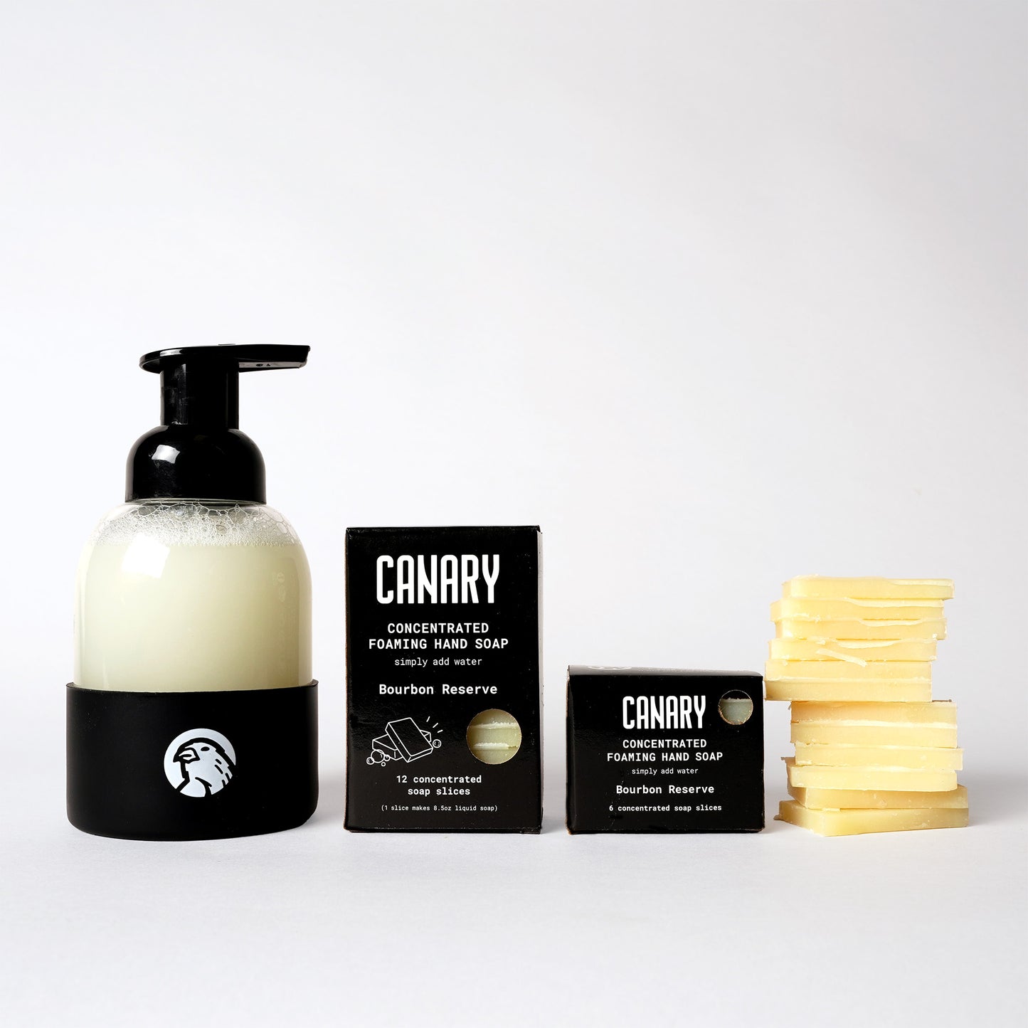 Image of Bourbon Reserve Foaming Hand Soap. 1 box containing 12 soap slices and 1 box containing 6 soap slices. Sustainable refillable glass bottle filled with soap and 12 soap slices next to product.