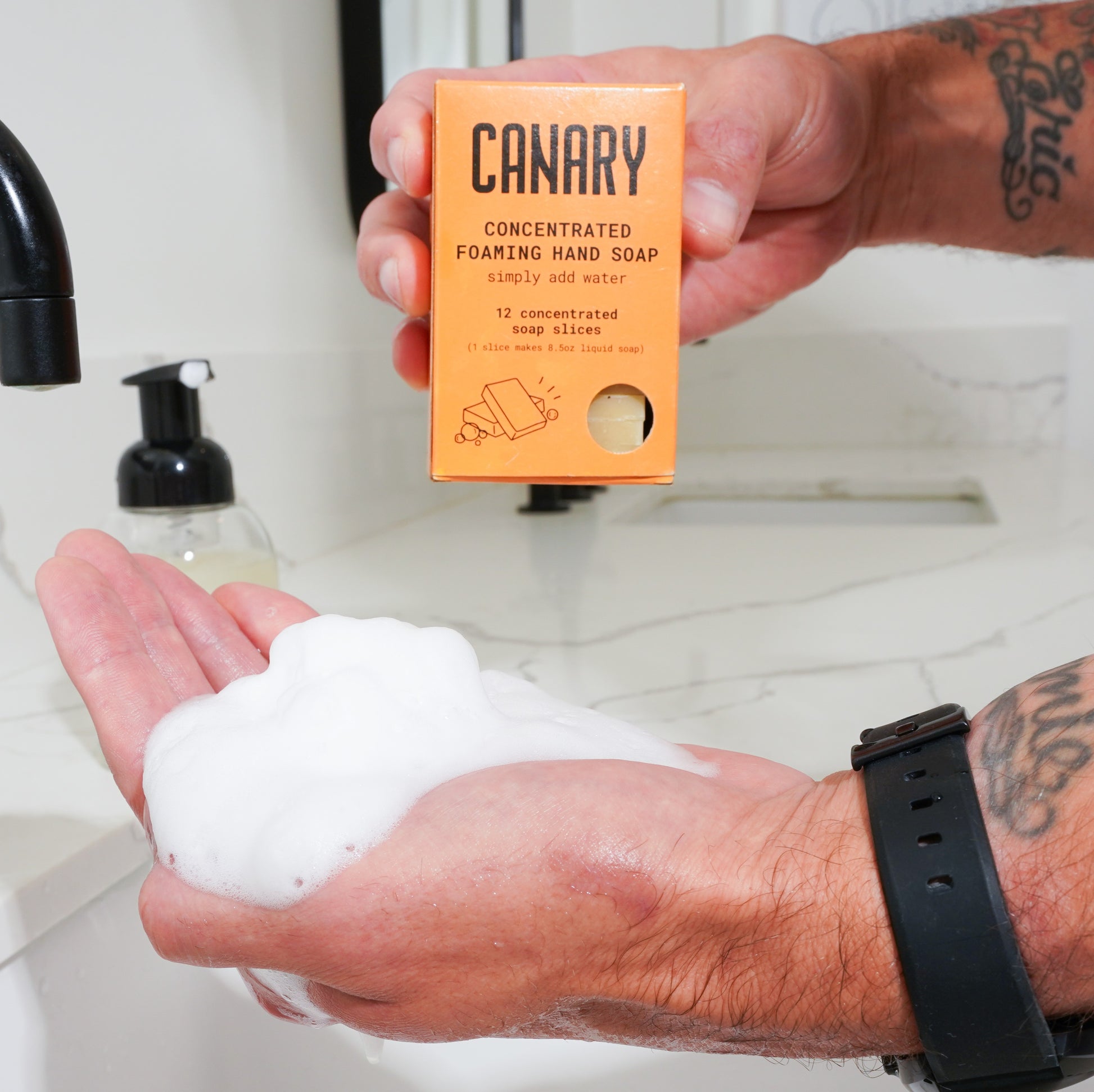 Cedar Mint Concentrated Foaming Hand Soap. Front of the box with hands in sink showing how foamy it gets.  12-count box.